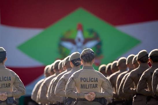 Sala com grande painel de cronograma de estudos para concurso policial militar