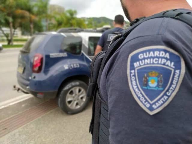 Candidato analisa simulação de salário da Guarda Municipal de Florianópolis em notebook com planilha e gráficos
